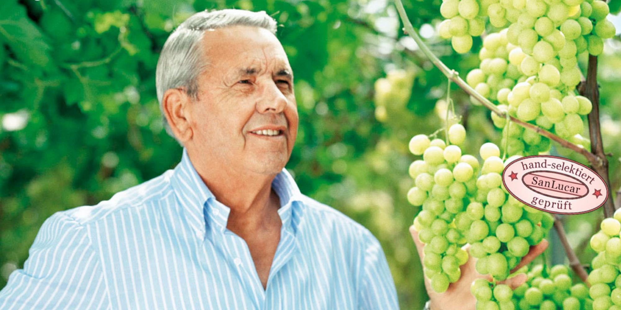 SanLucar Antonio Giuliano hält Weintrauben in der Hand